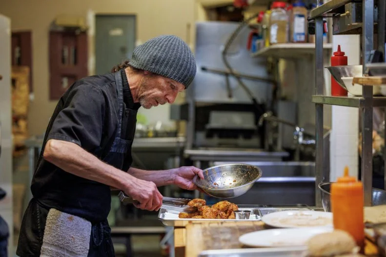 Cook Fred T plating wings in the kitchen