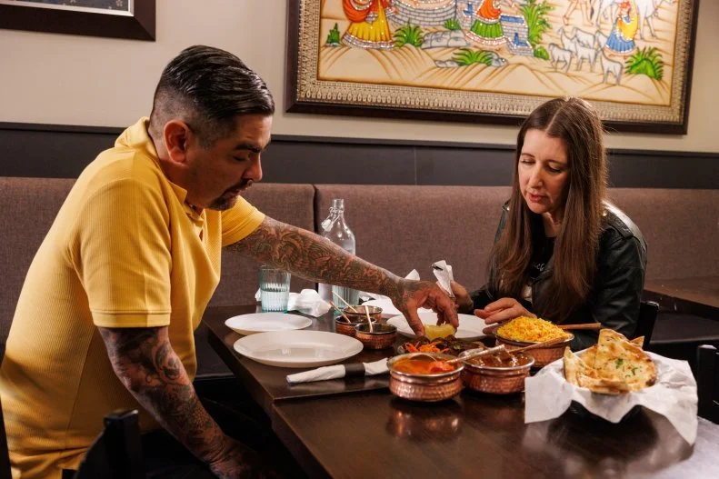 Hosts Aaron Sanchez and Jenn Agg in the dining room of Spicy Affairs, as seen on Restaurant Impossible: Last Call, Season 1