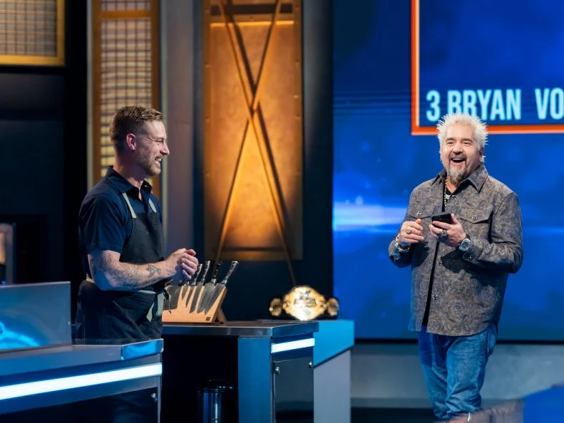 Host Guy Fieri and contestant Bryan Voltaggio as he is announced the winner of the round, as seen on Tournament of Champions, Season 7.