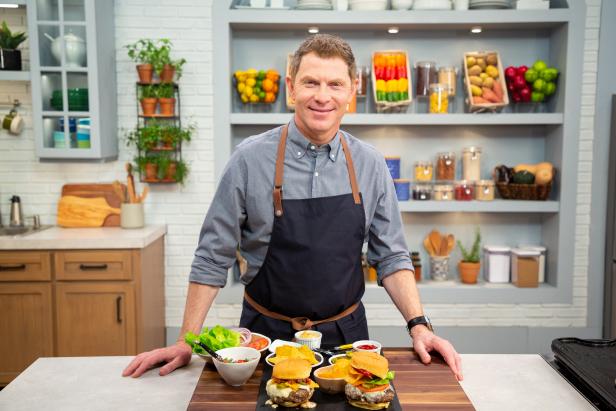 Bobby Flay posing with Burger 101, as seen on Food Network Kitchen Live.