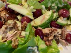 I grew up blocks away from the Waldorf Astoria hotel in New York City. I remember walking by the heralded building as a kid and wondering if all the guests inside were eating nothing but Waldorf salad. I imagined the hotel must have needed a lot of grapes, walnuts and mayonnaise! When I first made the salad as a young chef in Larry Forgione's kitchen decades later, I marveled at how good this salad can be when it's treated with care. A small cheffy note: The confectioners' sugar on the grapes brings out more of their vibrant color when you roast them, making for a tasty, delicate balancing act between them and the lettuce on one side and the roasted chicken, crunchy walnuts and mayonnaise-style dressing on the other. I like to mix this salad together at the very last minute so the flavors are all still independently delicious and therefore even better when eaten all together.