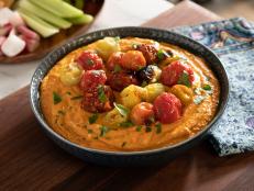 This smoky red pepper hummus is bursting with flavor from the roasted red pepper and charred tomatoes. The secret to this shortcut hummus is boiling the canned chickpeas, which results in the most silky texture.