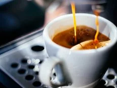 Espresso shot pouring out of a espresso machine.