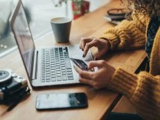 Woman in cafe shopping online with laptop