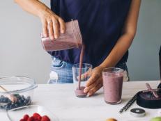Woman pouring smoothie into glasses