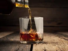 Pouring glass of whiskey, Close-up whisky on the rocks.