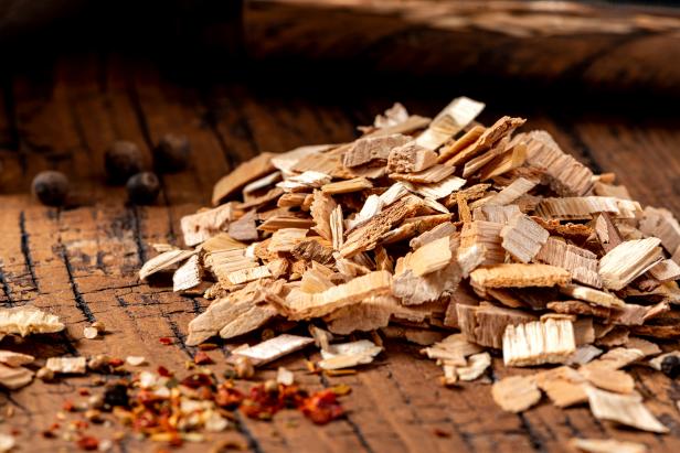 Wood chips for smoking meat or fish on an old wooden table close-up.