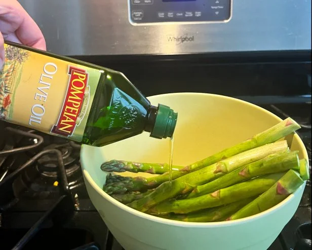 Pompeian Olive Oil drizzled over asparagus