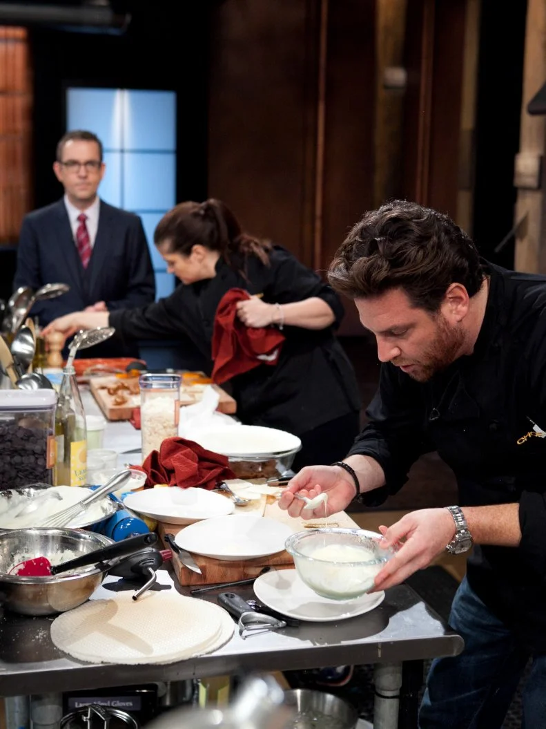 Chopped: After Hours host Ted Allen talks with chef Alex Guarnaschelli while she and Scott Conant work on their desserts that must include: vanilla pudding cups, wafer sheets, lemon soda and a torch, as seen on Food Network's Chopped: After Hours.