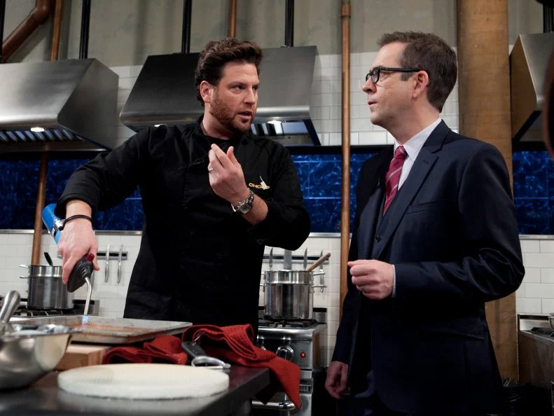 Chopped: After Hours host Ted Allen talks with chef Scott Conant while he works on his dessert that must include: vanilla pudding cups, wafer sheets, lemon soda and a torch, as seen on Food Network's Chopped: After Hours.