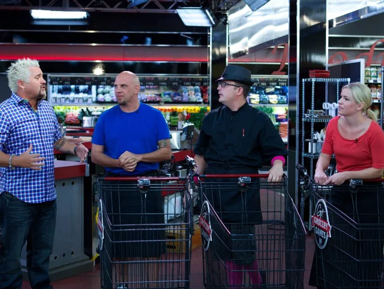 Host Guy Fieri with chefs Shane Miller, Daniel Vercher and Kristina White during the start of the shopping part of Game 2, Closing Time, Ultimate Hot Dog, 2 min shopping and 30 min cooking time, as seen on Food Network's Guy's Grocery Games, Season 1.