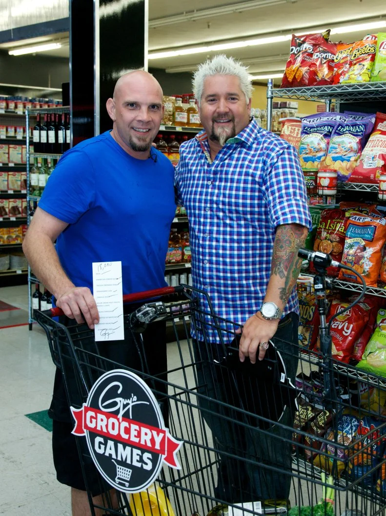 Host Guy Fieri poses with chef Shane Miller,  during the the shopping spree with a chance to win $20,000 by grabbing all the items on the grocery list within 2 minutes, as seen on Food Network's Guy's Grocery Games, Season 1.