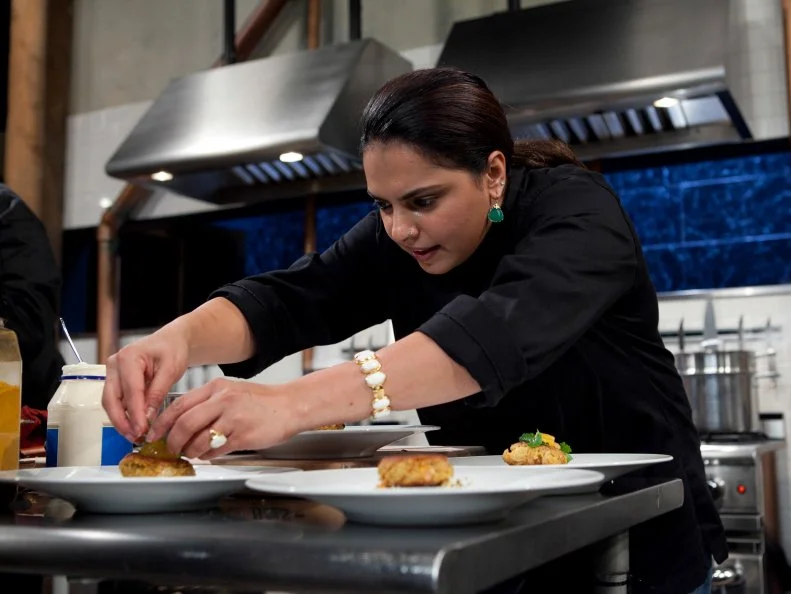 Chopped: After Hours chef Maneet Chauhan works on her appetizer that must include: pickled pigs feet, butter beans, coleslaw mix and sweet potato chips, as seen on Food Network's Chopped: After Hours.