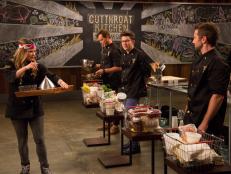 Chef Nadia Giosia decides who to deliever the sabotage element, Assign Cooking Vessel, to during the Round 1 auction, as seen on Food Network's Cutthroat Kitchen, Season 5.