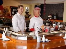 Chef Bobby Flay and Chef Anne Burrell present the Sushi Skill Drill Challenge to the two competing teams.  The Red and Blue team recruits must prepare two sushi dishes for a hungry lunchtime crowd and are tested on both their time & quantity: A California Roll with snow crab, nori, rice on the outside, garnished with sesame seeds and a Salmon Roll with sliced salmon, scallion, sushi rice, spicy mayo (with nori on the outside.)  The diners will determine which team will win the challenge, as seen on Food Network's Worst Cooks in America, Season 5.