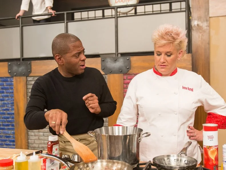 Cast Member Jamie Thomas cooks as Anne Burrell and Bobby Flay watch as seen on Food Networkâ  s Worst Cooks in America, Season 5.