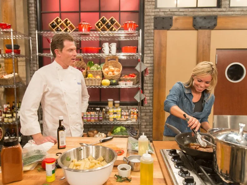 Chef Bobby Flay looks on as cast member Carie Keller cooks as seen on Food Networkâ  s Worst Cooks in America, Season 5.