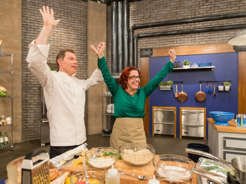 Chef Bobby Flay and cast member Carol Holder hold their hands up at the end of a cooking challenge as seen on Food Networkâ  s Worst Cooks in America, Season 5.