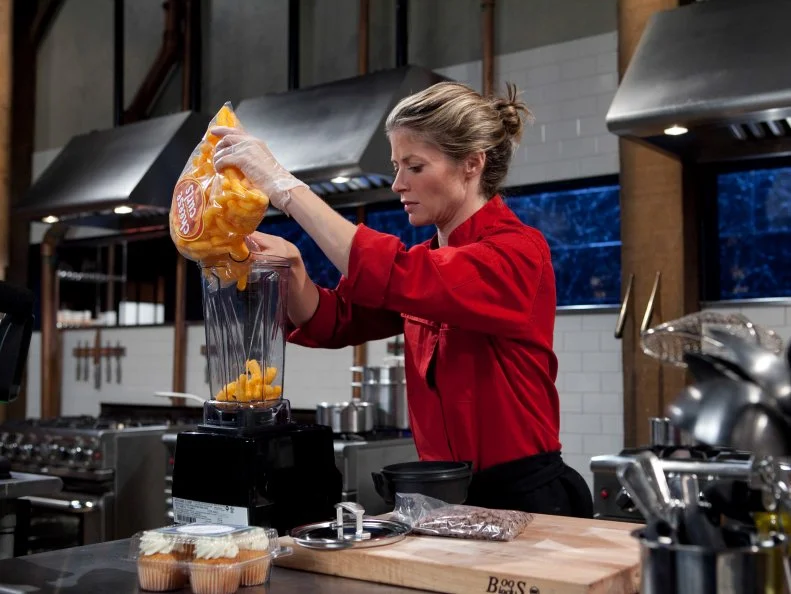 Celebrity Gillian Vigman working on her dessert that must include: cinnamon chips, cheese curls, vanilla cupcakes and apple cider, as seen on Food Networkâ  s Chopped, Season 19.