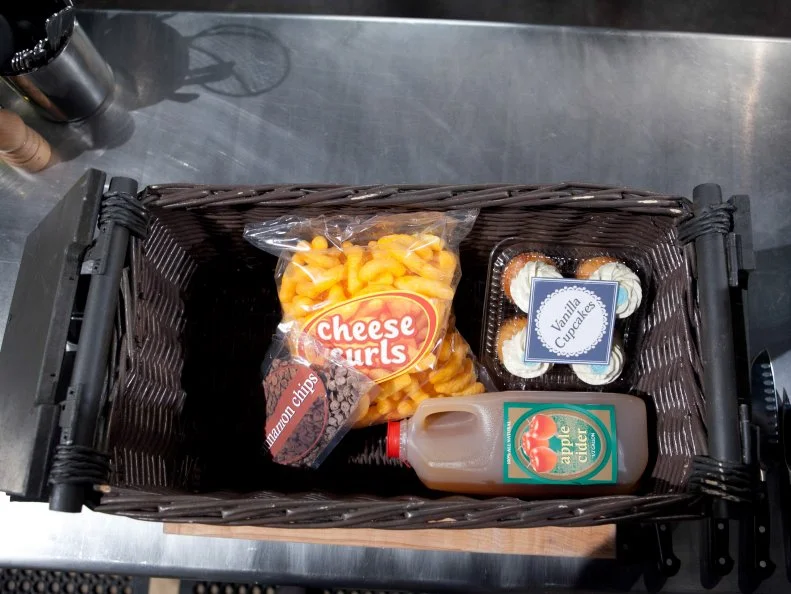 The mystery basket ingredients for the dessert round are: cinnamon chips, cheese curls, vanilla cupcakes and apple cider, as seen on Food Networkâ  s Chopped, Season 19.