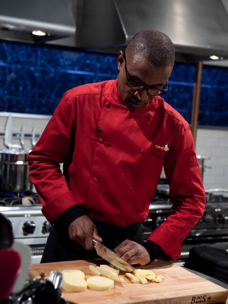 Celebrity Tommy Davidson working on his appetizer that must include: pickled pig lips, polenta, spinach and gummy eggs, as seen on Food Networkâ  s Chopped, Season 19.
