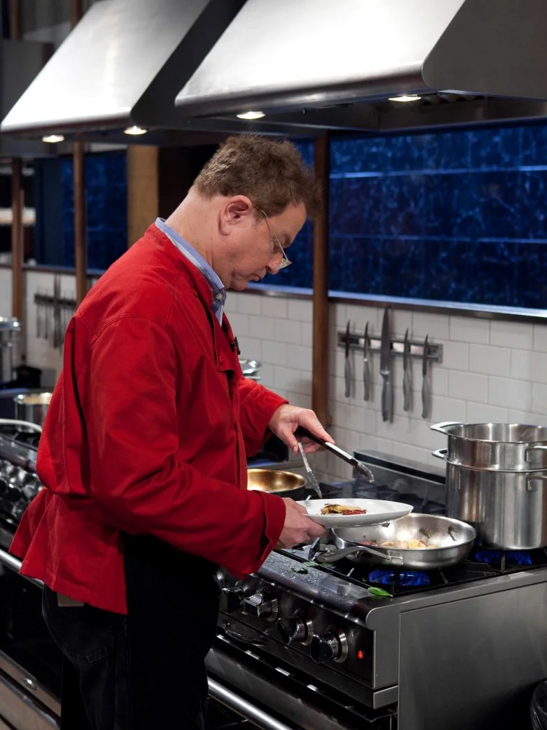 Celebrity Robert Wuhl working on his appetizer that must include: pickled pig lips, polenta, spinach and gummy eggs, as seen on Food Networkâ  s Chopped, Season 19.