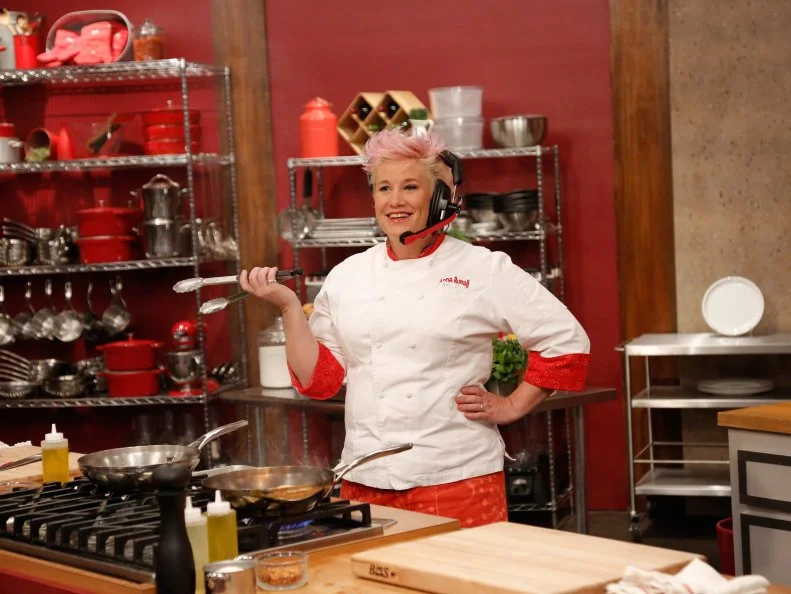 Red Team Leader Chef Anne Burrell tries to understand what her team is describing to her about the flavors in their Halibut with Endive and Gremolata, so she can replicate them, during the Remote Control Skill Drill. The Red Team, Mike Glazer and Jamie Thomas, must direct her via headset to make the same dish they are seeing for the first time, as seen on Food Network's Worst Cooks in America, Season 5.