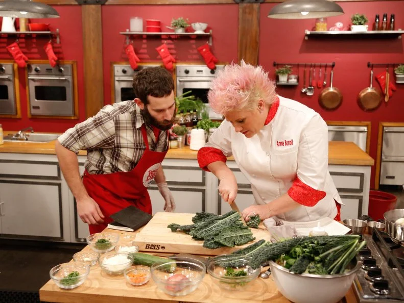 Read Team Leader Chef Anne Burrell steps in to help Red Team recruit Mike Glazer as he prepares his dish for his loved one, during the Feed the Family Challenge. Red Team recruit Mike Glazer has to prepare Red Team Leader Chef Anne Burrell's Sauteed Salmon fillet with Tzatziki and Warm Lentils, as seen on Food Network's Worst Cooks in America, Season 5.
