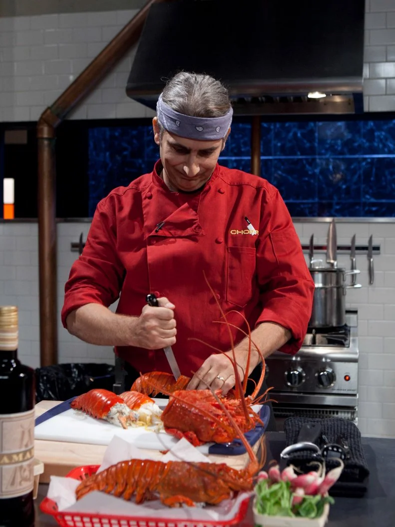 Celebrity Michael Imperioli working on his entree that must include: spiny lobster, pink variegated lemons, amaro and radish, as seen on Food Networkâ  s Chopped, Season 19.