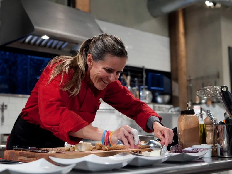 Celebrity Brandi Chastain working on her dessert that must include: blueberry goat cheese, pecans, churros, champagne, as seen on Food Networkâ  s Chopped, Season 19.
