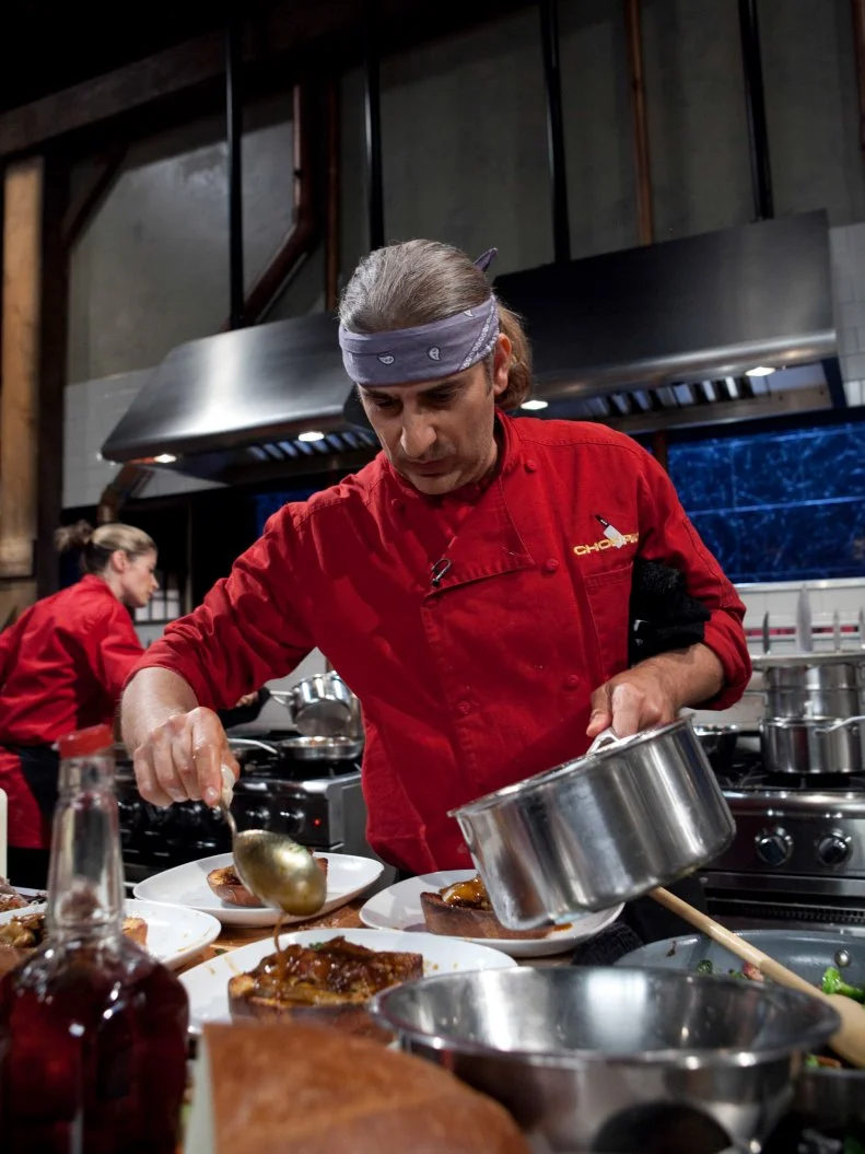 Celebrity Michael Imperioli working on his entree that must include: Peking duck, Brussels sprouts on the stalk, cotton candy and veal demi-glace, as seen on Food Networkâ  s Chopped, Season 19.