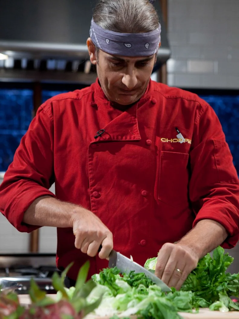 Celebrity Michael Imperioli working on his appetizer that must include: 10 pack of tacos, escarole, dragon fruit and vanilla ice cream, as seen on Food Networkâ  s Chopped, Season 19.