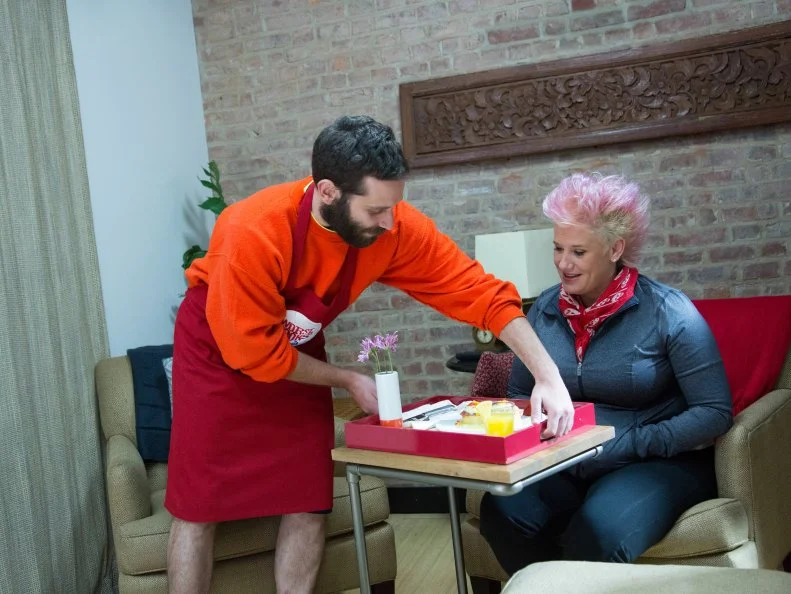 Red Team member Mike Glazer brings his completed Eggs Benedict with Prosciutto to Red Team Leader Chef Anne Burrell to taste during the Breakfast Skill Drill Challenge, as seen on Food Network's Worst Cooks in America, Season 5.