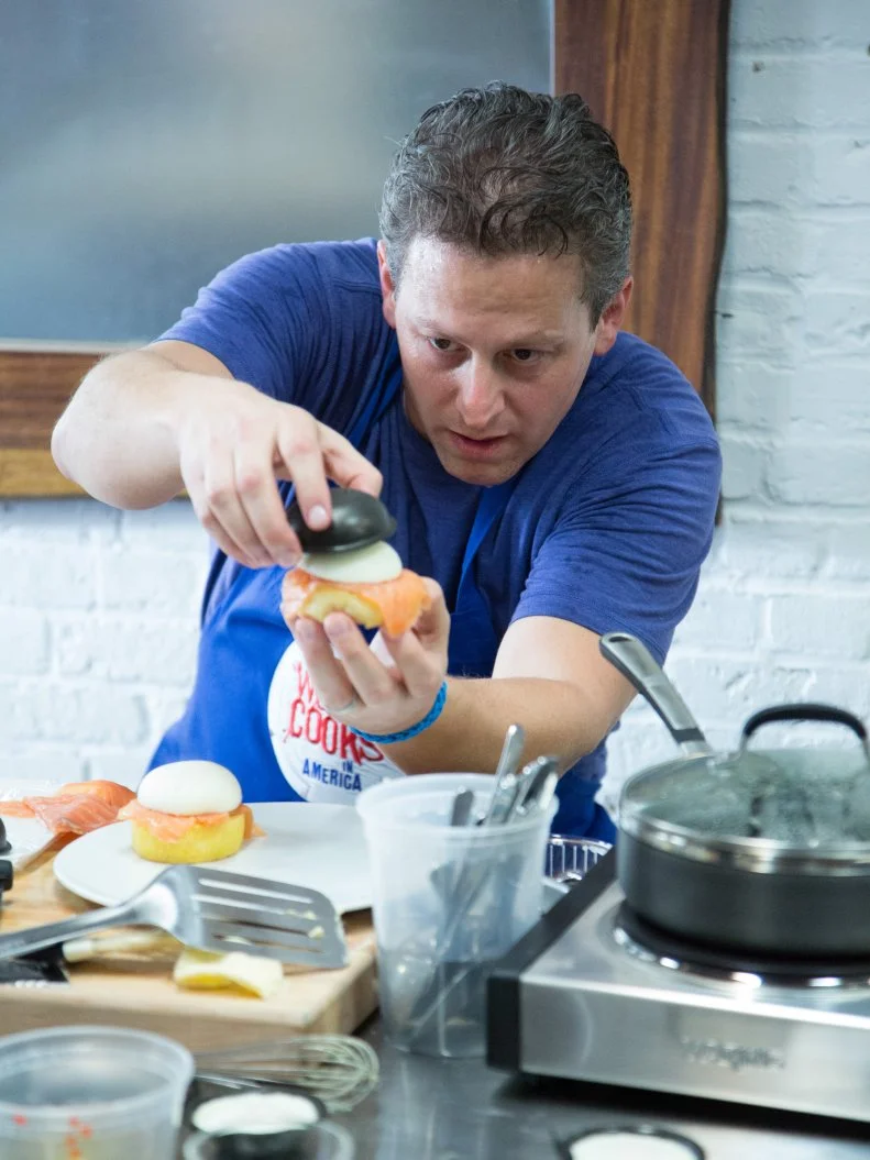 Blue Team member Daniel Beyda starts to assemble his team's dish for the Breakfast Skill Drill Challenge. Sarabeth demonstrated two variations of Eggs Benedict for the recruits, one for each of the teams to replicate; the Red Team making Eggs Benedict with Prosciutto, and Blue team, Eggs Benedict with Salmon. Unbeknownst to the recruits, Chef Bobby and Chef Anne observe their progress on a monitor, as they cook their dishes for the Breakfast Skill Drill Challenge, as seen on Food Network's Worst Cooks in America, Season 5.