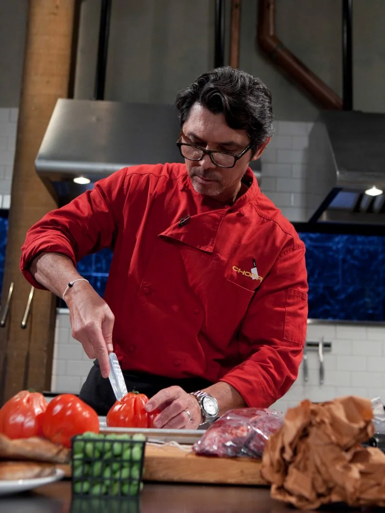 Celebrity Lou Diamond Phillips working on his entree that must include: buffalo hanger steak, watermelon cucumbers, ranch dip, pizza, as seen on Food Network's Chopped, Season 19.