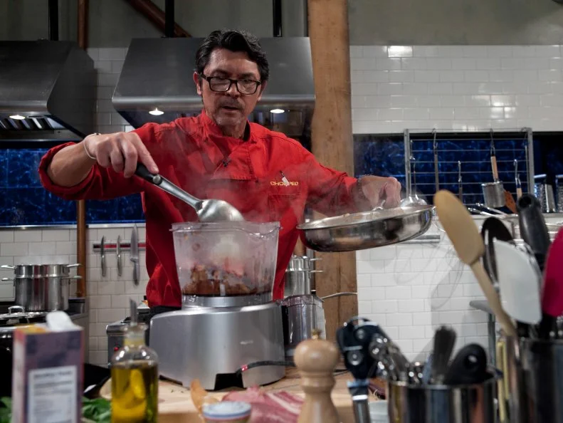 Celebrity Lou Diamond Phillips working on his appetizer that must include: beef tongue, candies citron, Chinese broccoli and microwave chocolate cake, as seen on Food Networkâ  s Chopped, Season 19