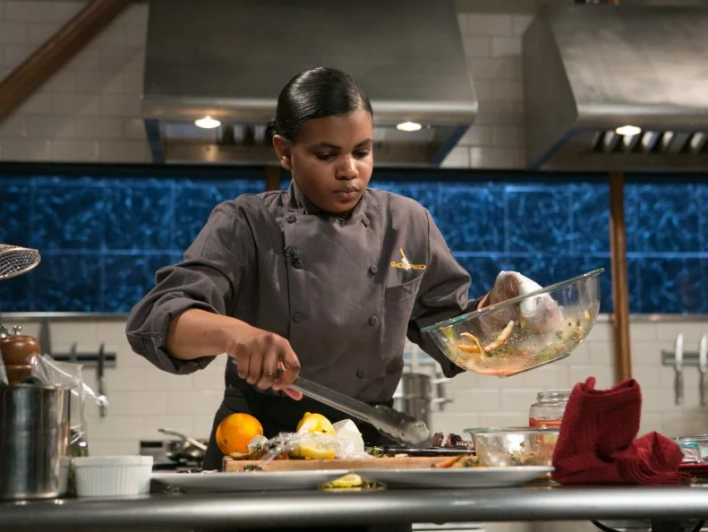 Teen Competitor Alexandria Brooks (16) working on her appetizer that must include: cherry-drink-soaked pickles, lamb loin chops, kale chips and ricotta salata, as seen on Food Network's Chopped, Season 21.