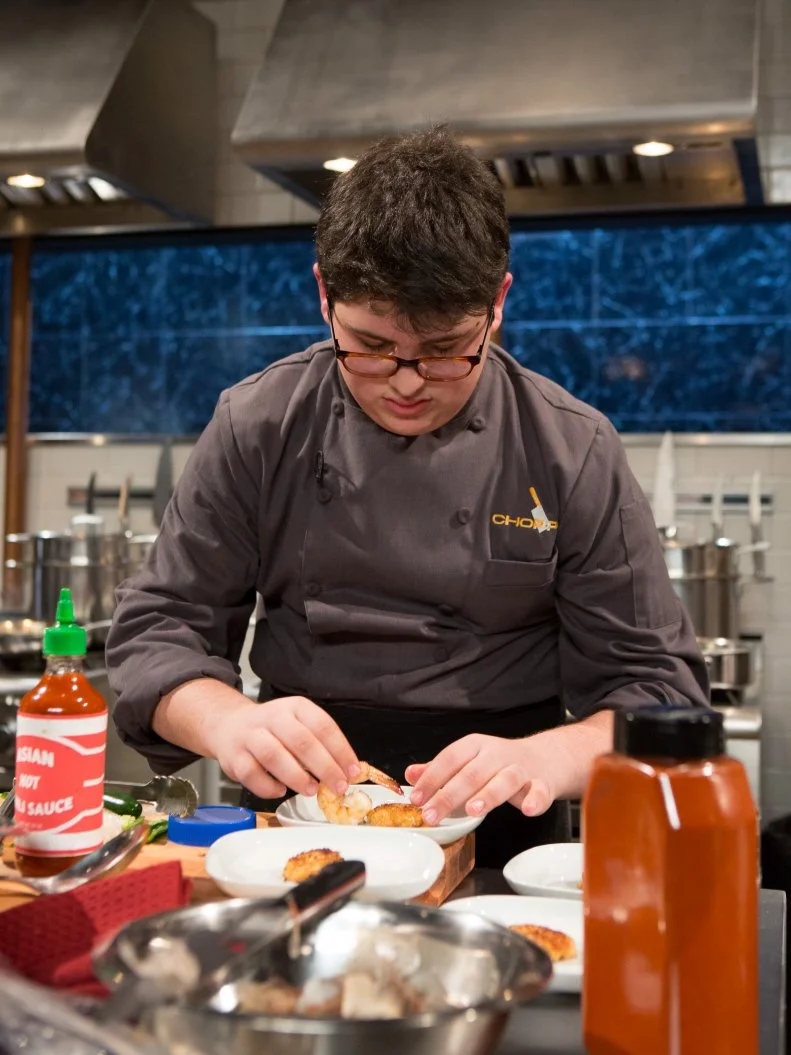 Teen competitor Eyan Goldman (16) working on his appetizer that must include: jumbo shrimp, chunky peanut butter, jalapeno and sticky rice, as seen on Food Network's Chopped, Season 21.