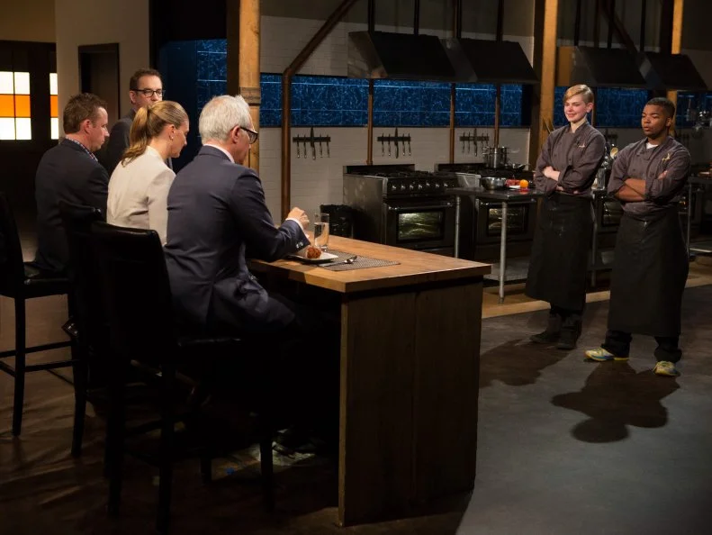 Teen competitors Lucy Felong (15) and Dante Foggy stand before Chopped host Ted Allen and judges: Geoffrey Zakarian, Amanda Freitag and Marc Murphy as they judge the teen competitors desserts that must have included: black and white cookies, fruit leather strips, cashews and agave nectar, as seen on Food Network's Chopped, Season 21.