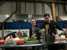 After Hours host Ted Allen watches chef Aaron Sanchez steal ingredients from fellow chef Amanda Freitag while they work on their dishes that must include:cherry drink soaked pickles, lamb chops, kale chips and ricotta salata, as seen on Food Network's Chopped After Hours, season 21.