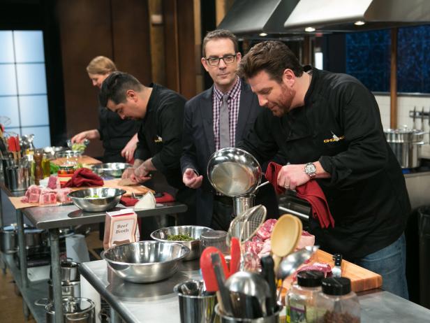 After Hours host Ted Allen checks in on chef Scott Conant while he works on his dish that must include: cherry drink soaked pickles, lamb chops, kale chips and ricotta salata, as seen on Food Network's Chopped After Hours, season 21.