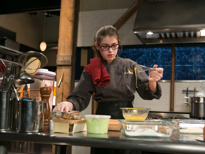 Teen competitor Hannah Bukzin (14) working on her entree that must include: pineapple upside-down cake, cornish hens, hen of the woods mushrooms and edamame hummus  as she competes for a slot in the Teen Challenge and a chance to win $25,000 and a $40,000 culinary school scholarship, as seen on Food Network's Chopped, season 21.