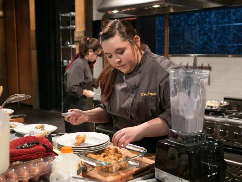 Teen Competitors: Hannah Bukzin (14) and Tommi Rae Fowler (16) working on their entrees that must include: pineapple upside-down cake, cornish hens, hen of the woods mushrooms and edamame hummus  as they compete for a slot in the Teen Challenge and a chance to win $25,000 and a $40,000 culinary school scholarship, as seen on Food Network's Chopped, season 21.