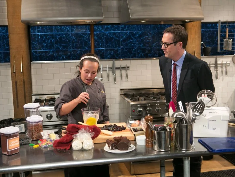 Chopped host Ted Allen checks in on teen competitor Morgan Goldstein (14) while she works on her dessert that must include: chocolate swiss rolls, gummy fish, blackberries and popcorn balls, as she competes for a slot in the Teen Challenge and a chance to win $25,000 and a $40,000 culinary school scholarship, as seen on Food Network's Chopped, season 21.