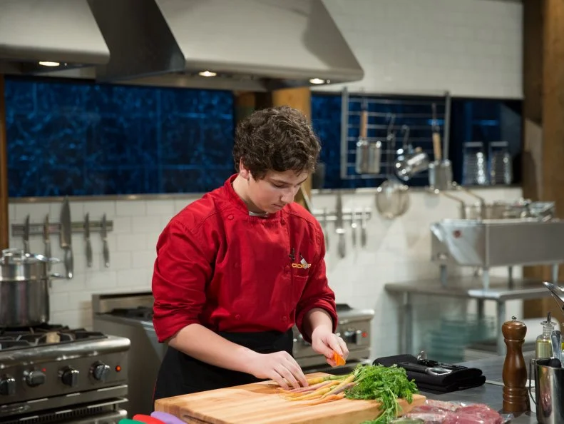 Teen competitor Jason Khaytin cooking during a competition, as seen on Food Networkâ  s Chopped, Season 21.
