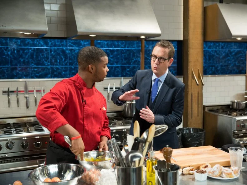 Host Ted Allen walks with Teen competitor Dante Foggy during competition, as seen on Food Networkâ  s Chopped, Season 21.