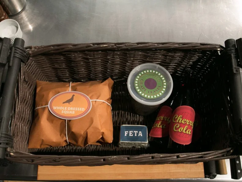 The entree round mystery basket ingredients are: whole dressed squab, stuffed grape leaves, feta cheese and cherry cola, as seen on Food Network's Chopped, Season 21.