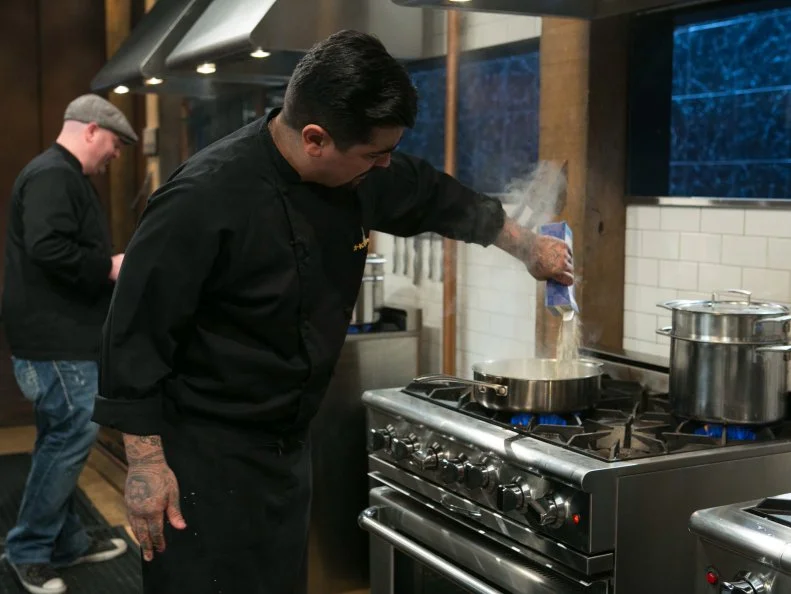 Chefs Chris Santos and Aaron Sanchez work on their dishes that must include: eel, pepihuates, shaved coconut and sea beans, as seen on Food Network's Chopped, Season 21.