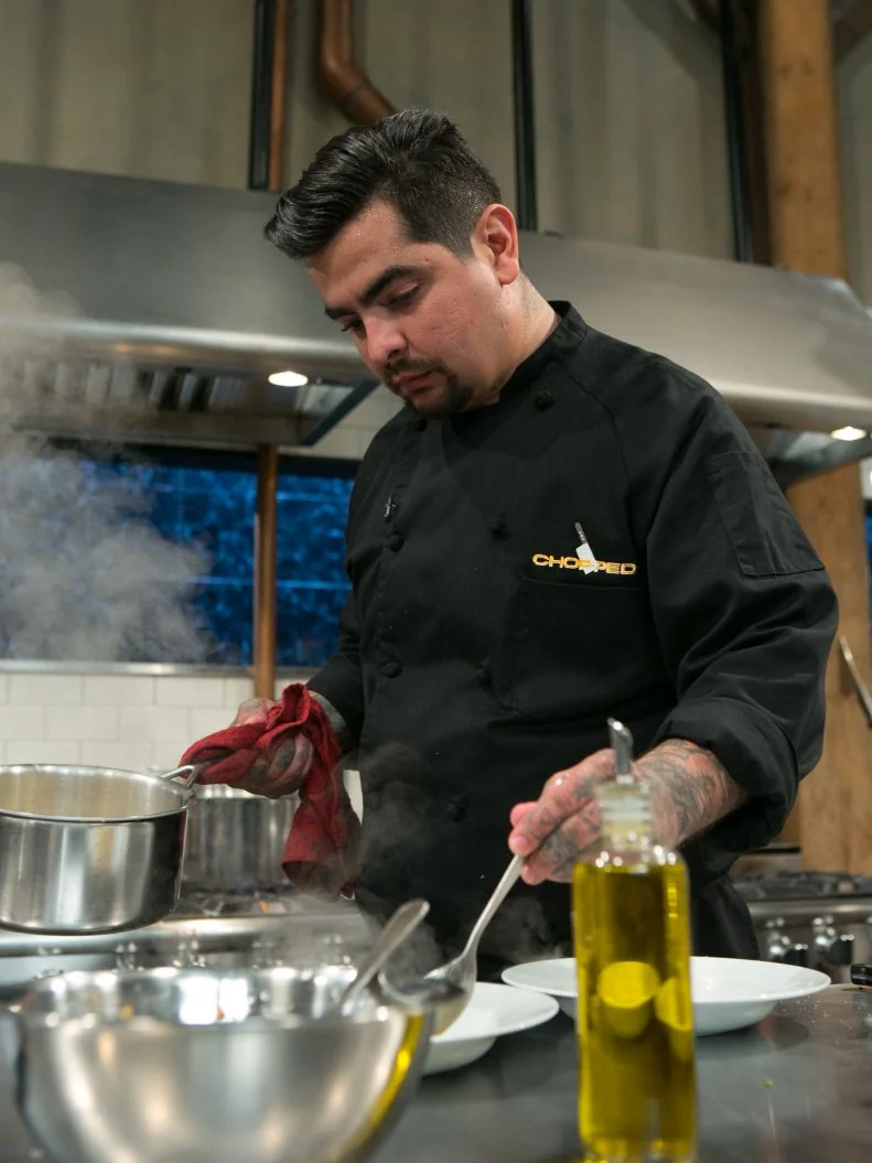 Chef Aaron Sanchez working on his dish that must include: eel, pepihuates, shaved coconut and sea beans, as seen on Food Network's Chopped, Season 21.