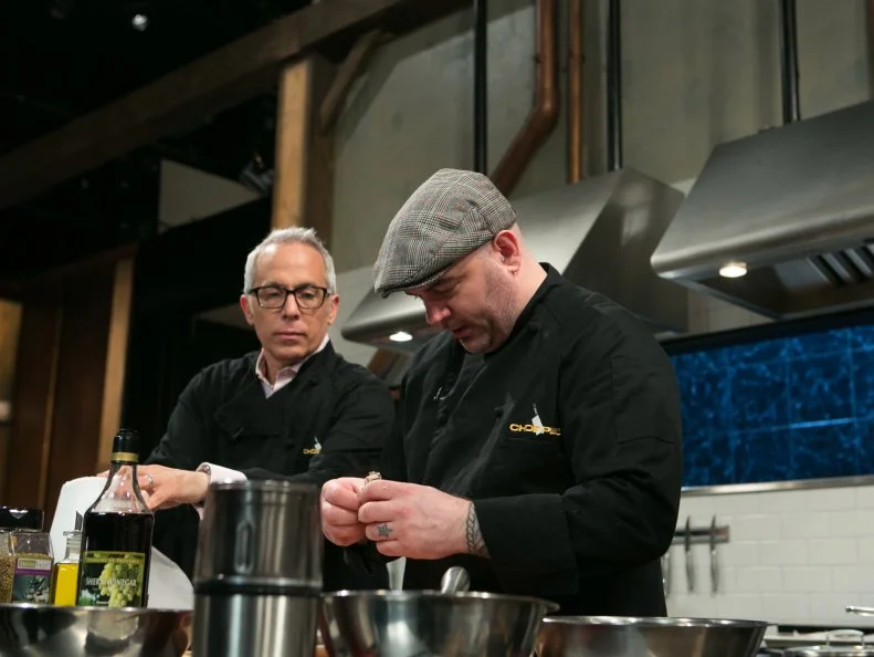 Chef Geoffrey Zakarian makes fun on chef Chris Santos while they both work on their dishes that must include: eel, pepihuates, shaved coconut and sea beans, as seen on Food Network's Chopped, Season 21.